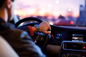 man wearing watch steering car